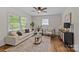 Bright living room features hardwood floors, modern decor, a ceiling fan and ample natural light at 1814 Brookdale Ave, Charlotte, NC 28210