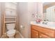 Bright bathroom showcasing a white toilet, wood-trimmed vanity, and natural light from the window at 186 Gresham Ln, Mooresville, NC 28117