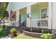 Detailed view of the front porch with an American flag, rocking chair, and landscaped flower bed at 186 Gresham Ln, Mooresville, NC 28117