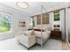 Elegant bedroom with a four-poster bed, neutral decor, and natural light from large windows at 188 Blarney Rd, Mooresville, NC 28117