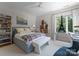 A cozy bedroom features a grey bed, a modern white bench and a beautiful shelf and book at 188 Blarney Rd, Mooresville, NC 28117