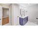 Modern bathroom with double sinks, square mirror, and a door leading to an adjacent room at 2000 Tyvola Rd, Charlotte, NC 28210