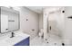 Bathroom featuring a glass enclosed shower, marble tile, blue vanity and modern fixtures at 2000 Tyvola Rd, Charlotte, NC 28210