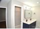Bathroom with double sink vanity, modern lighting, and an adjacent walk-in closet at 2000 Tyvola Rd, Charlotte, NC 28210