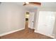 Bedroom with wood floors, ceiling fan, closet and view into kitchen at 2000 Tyvola Rd, Charlotte, NC 28210