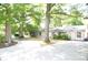 Home's front exterior, showcasing a concrete driveway and mature trees at 2000 Tyvola Rd, Charlotte, NC 28210