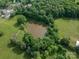Aerial view of a tranquil pond surrounded by lush greenery and mature trees at 2865 Water Plant Rd, Maiden, NC 28650