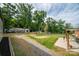 Expansive backyard featuring a gravel driveway, mature trees, and multiple outbuildings at 2865 Water Plant Rd, Maiden, NC 28650