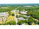 Wide aerial of commercial property surrounded by lush green trees with a neighborhood and highway nearby at 3042 N Oxford St, Claremont, NC 28610