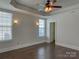 Spacious bedroom featuring a ceiling fan, wood floors, neutral paint, and natural light from two windows at 4135 Twenty Grand Dr, Indian Trail, NC 28079