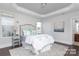 Bright bedroom featuring a bed, wood floors, and a tray ceiling with natural light coming in through two windows at 4135 Twenty Grand Dr, Indian Trail, NC 28079