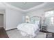 Well-lit bedroom featuring a tray ceiling, wood floors, and two windows allowing natural light at 4135 Twenty Grand Dr, Indian Trail, NC 28079