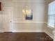Bright dining room featuring hardwood floors, stylish chandelier, and elegant wainscoting at 4135 Twenty Grand Dr, Indian Trail, NC 28079