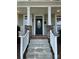 Inviting front entrance with stone accents, oval glass door, and a classic porch at 4135 Twenty Grand Dr, Indian Trail, NC 28079