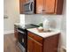 Stylish kitchen with wooden cabinets, stainless steel microwave, white subway tile backsplash, and light countertops at 4135 Twenty Grand Dr, Indian Trail, NC 28079