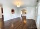 Open living room with hardwood floors flowing into dining area, accentuated by archways and natural light at 4135 Twenty Grand Dr, Indian Trail, NC 28079