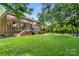 Lush backyard featuring mature trees, a deck, and a play area at 4389 Enchantment Cove Ln, Charlotte, NC 28216
