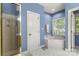 Light blue bathroom featuring a large soaking tub with a window, and a stand up shower at 4389 Enchantment Cove Ln, Charlotte, NC 28216