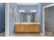 Stylish bathroom with dual sink vanity, well-lit mirror and complementary blue wall at 4389 Enchantment Cove Ln, Charlotte, NC 28216