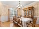 Formal dining room boasts hardwood floors, large window, and elegant chandelier at 4389 Enchantment Cove Ln, Charlotte, NC 28216