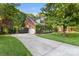 Long driveway leads to a charming brick home with lush greenery and a basketball hoop at 4389 Enchantment Cove Ln, Charlotte, NC 28216