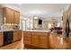 Open-concept kitchen features wood floors, an island, stainless appliances, and adjoins a comfortable living area at 4389 Enchantment Cove Ln, Charlotte, NC 28216