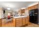Open kitchen layout with wood floors, a center island, stainless appliances, and access to a living area at 4389 Enchantment Cove Ln, Charlotte, NC 28216