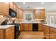 Light wood kitchen offers stainless appliances, white countertops, and sight lines into other living spaces at 4389 Enchantment Cove Ln, Charlotte, NC 28216