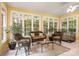 Bright sunroom features multiple windows, wicker furniture, and a neutral rug creating a cozy sitting area at 4389 Enchantment Cove Ln, Charlotte, NC 28216