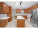 Well-lit kitchen with stainless steel appliances, white countertops, wood cabinets and a kitchen island at 4467 Antelope Ln, Charlotte, NC 28269