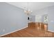 Spacious open-concept living area with hardwood floors, neutral paint, and chandelier lighting fixtures at 4467 Antelope Ln, Charlotte, NC 28269