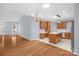 Open-concept living and dining area with hardwood floors leading to a kitchen with stainless steel appliances at 4467 Antelope Ln, Charlotte, NC 28269