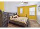 Comfortable bedroom with bright yellow walls, plush carpet, and a large bed, perfect for relaxing at 4935 Norman Park Pl, Clover, SC 29710