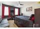 Well-lit bedroom with a dark accent wall, red curtains, and comfortable furnishings at 4935 Norman Park Pl, Clover, SC 29710