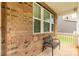 Charming front porch with brick siding, a comfortable bench, and a view of the well-maintained lawn at 4935 Norman Park Pl, Clover, SC 29710