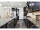 Stylish kitchen showcasing dark cabinetry, stainless-steel appliances, and granite countertops at 4935 Norman Park Pl, Clover, SC 29710