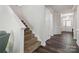 Carpeted staircase with white trim and hardwood floors in the foyer at 4935 Norman Park Pl, Clover, SC 29710