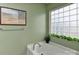Bright bathroom with a soaking tub, glass block window, and modern fixtures at 5011 Blue Stream Ln, Indian Trail, NC 28079
