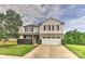 Charming two-story home featuring stone accents, a well-manicured lawn, and an attached two-car garage at 5011 Blue Stream Ln, Indian Trail, NC 28079