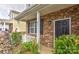 Inviting entryway featuring a brick facade, a black front door, and lush landscaping at 5011 Blue Stream Ln, Indian Trail, NC 28079