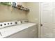 Functional laundry room with washer, dryer, and shelving for storage at 5011 Blue Stream Ln, Indian Trail, NC 28079