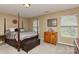Comfortable main bedroom with four-poster bed, hardwood floors, and ample natural light at 5011 Blue Stream Ln, Indian Trail, NC 28079