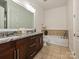 Relaxing bathroom featuring dual sinks, granite counters, tile flooring, and a soaking tub at 5425 Closeburn Rd, Charlotte, NC 28210
