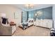 Bright bedroom with blue accent wall, decor, chair, and plush carpet at 5957 Redwood Pine Rd, Concord, NC 28027