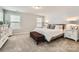 Bright bedroom with accent wall, bench, and plush neutral carpet at 5957 Redwood Pine Rd, Concord, NC 28027