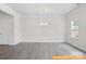 Open dining room area with a stylish chandelier, large window, and luxury vinyl flooring at 6005 Jasmine Branch Rd, Charlotte, NC 28216