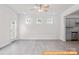 Bright living room featuring three square windows, a ceiling fan, and open access to the kitchen at 6005 Jasmine Branch Rd, Charlotte, NC 28216