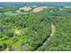 Lush greenery and a winding road surround a home, complemented by distant fields, providing both privacy and accessibility at 615 Hawley Rd, McConnells, SC 29726