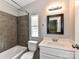 Tiled bathroom features a shower-tub combo, neutral vanity, and a window for natural light at 615 Hawley Rd, McConnells, SC 29726