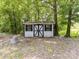 Outdoor storage shed with a closed door and black and white trim in the backyard at 615 Hawley Rd, McConnells, SC 29726